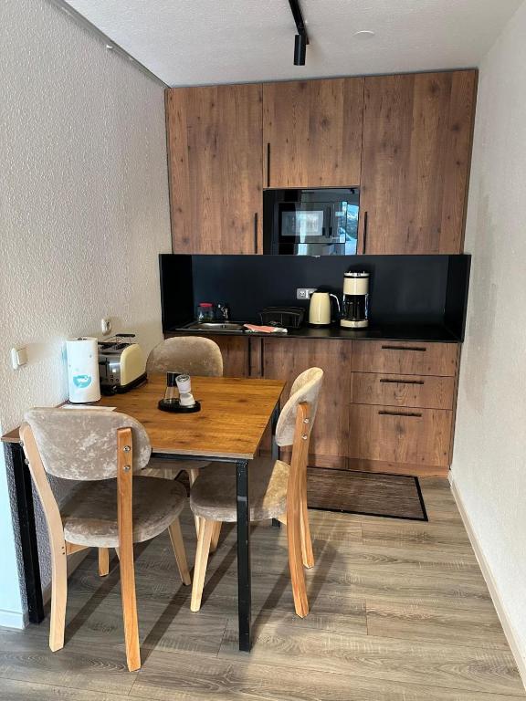 a kitchen with a wooden table and chairs in a room at Apartmenthaus Zeuthen 1 in Zeuthen