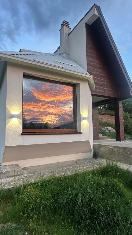 a reflection of a sunset in a window of a house at Villa Luce in Kolašin