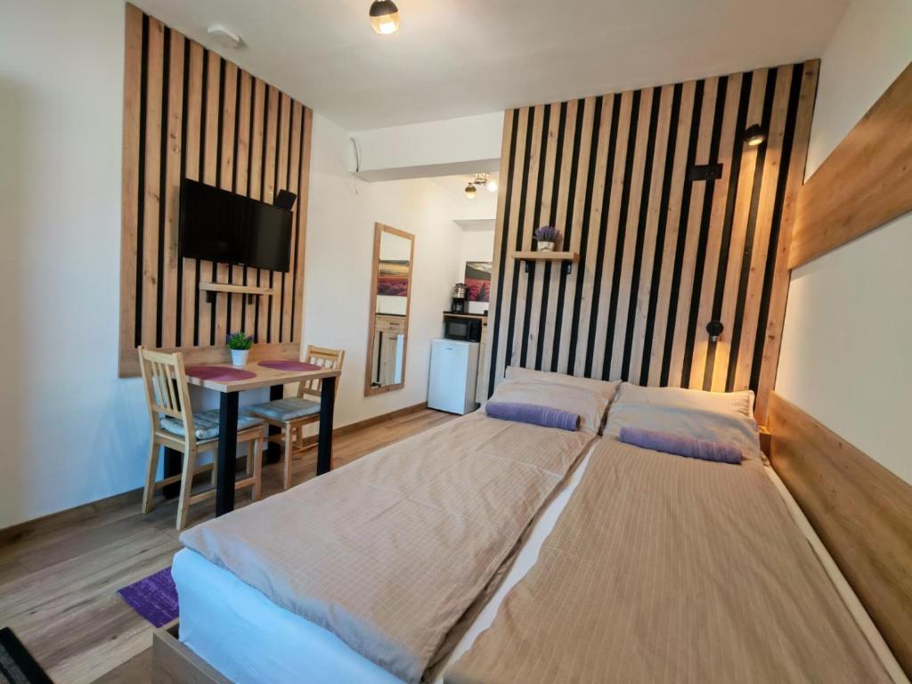 a bedroom with a large bed and a table at Somni Apartamente in Chinteni