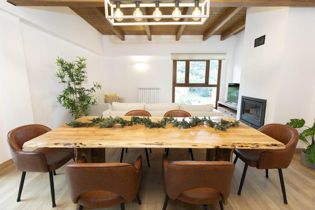 a dining room with a wooden table and chairs at Sueños del Garmo by BeValle in Panticosa