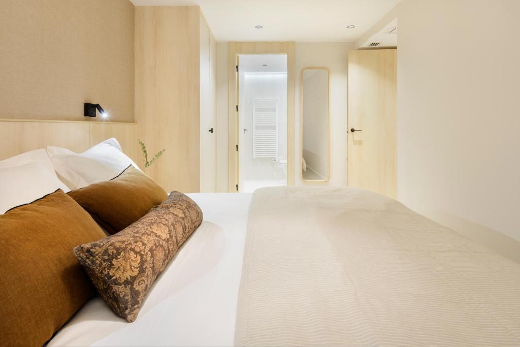 a bedroom with a large white bed with brown pillows at CiMa Panticosa by BeValle in Panticosa