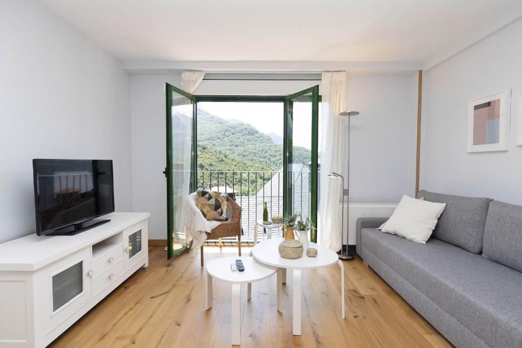 a living room with a couch and a tv at Ripereta by BeValle in Panticosa