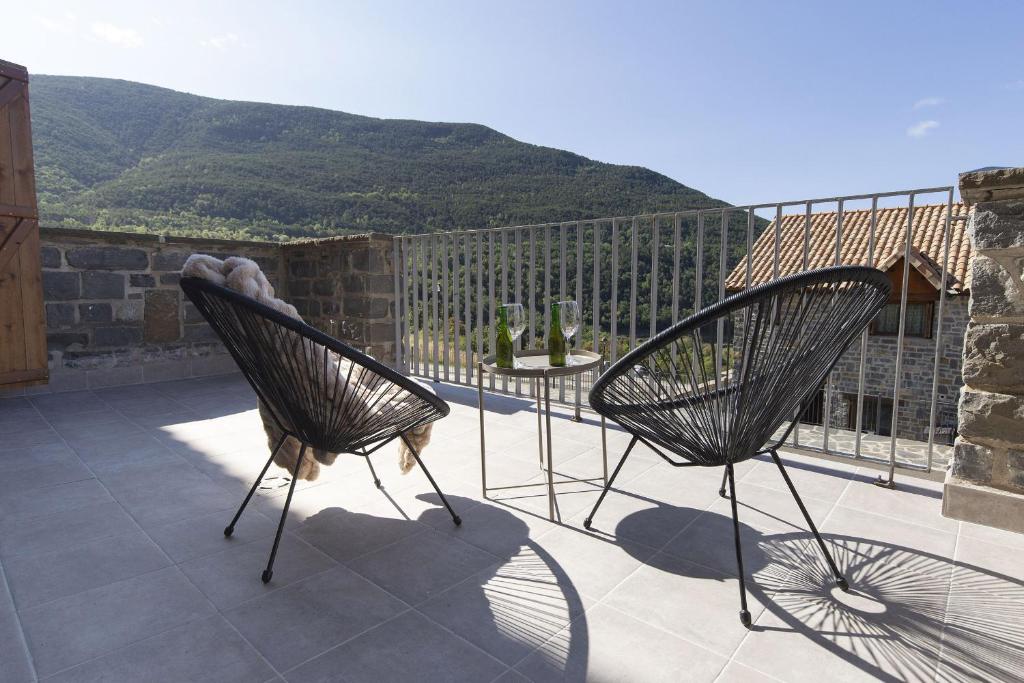two chairs on a patio with a view of a mountain at Aura de Gavin by BeValle in Buesa