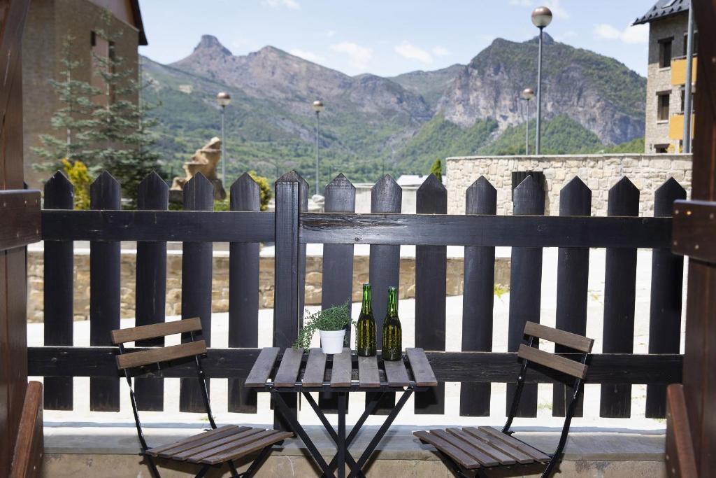 a table and chairs on a balcony with a fence at PanticAsa Azul by BeValle in Panticosa
