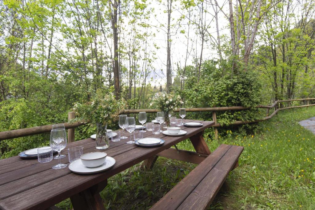 a wooden picnic table with glasses and plates on it at Casa Vity by BeValle in Panticosa