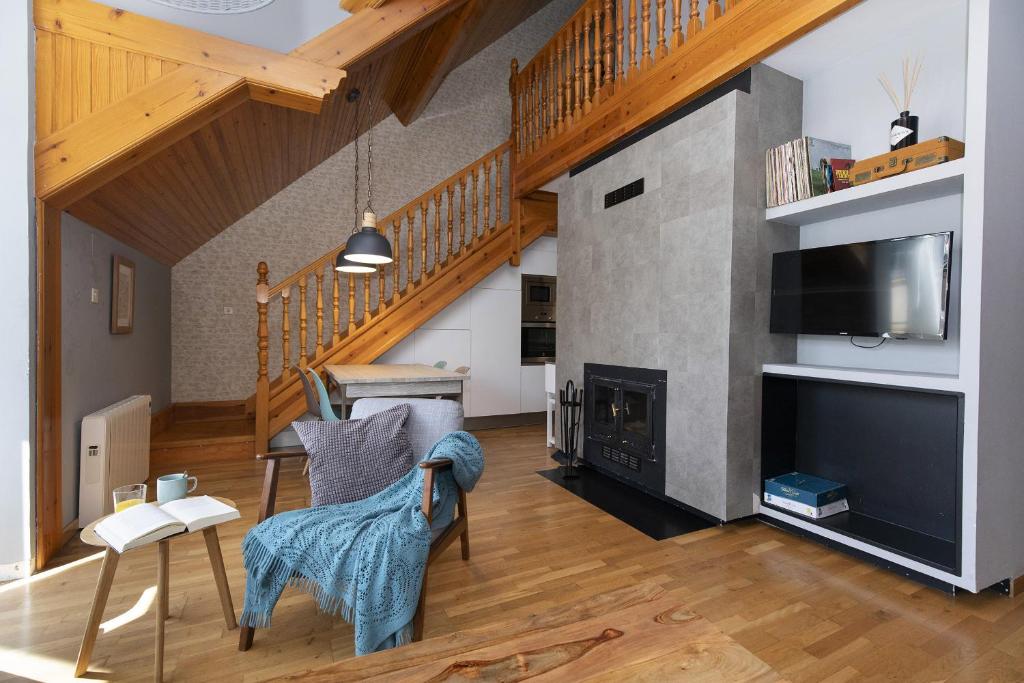 a living room with a fireplace and a tv at Ático de Pao by BeValle in Panticosa
