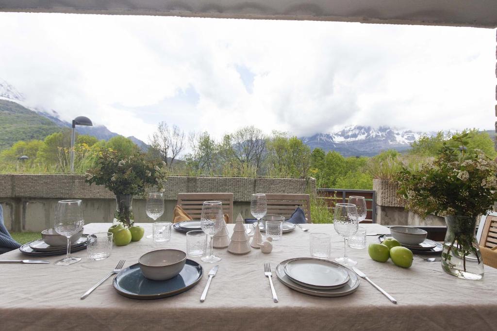 a table with plates and glasses on a table with a view at La Ventana de Saras by BeValle in Panticosa