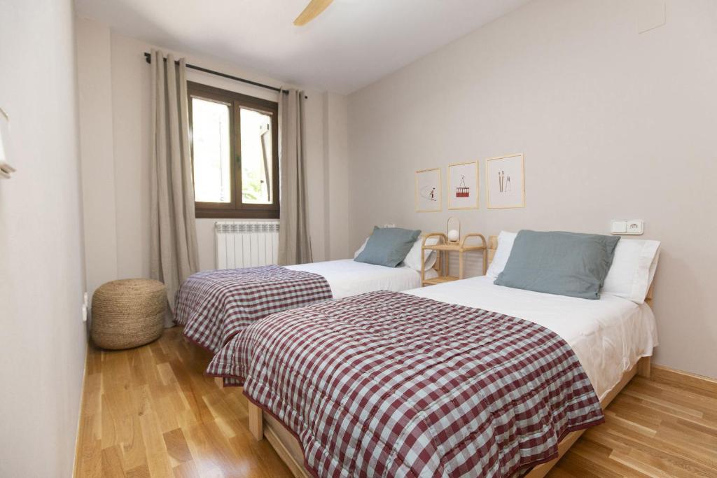a bedroom with two beds and a window at Balaitus by BeValle in Escarrilla
