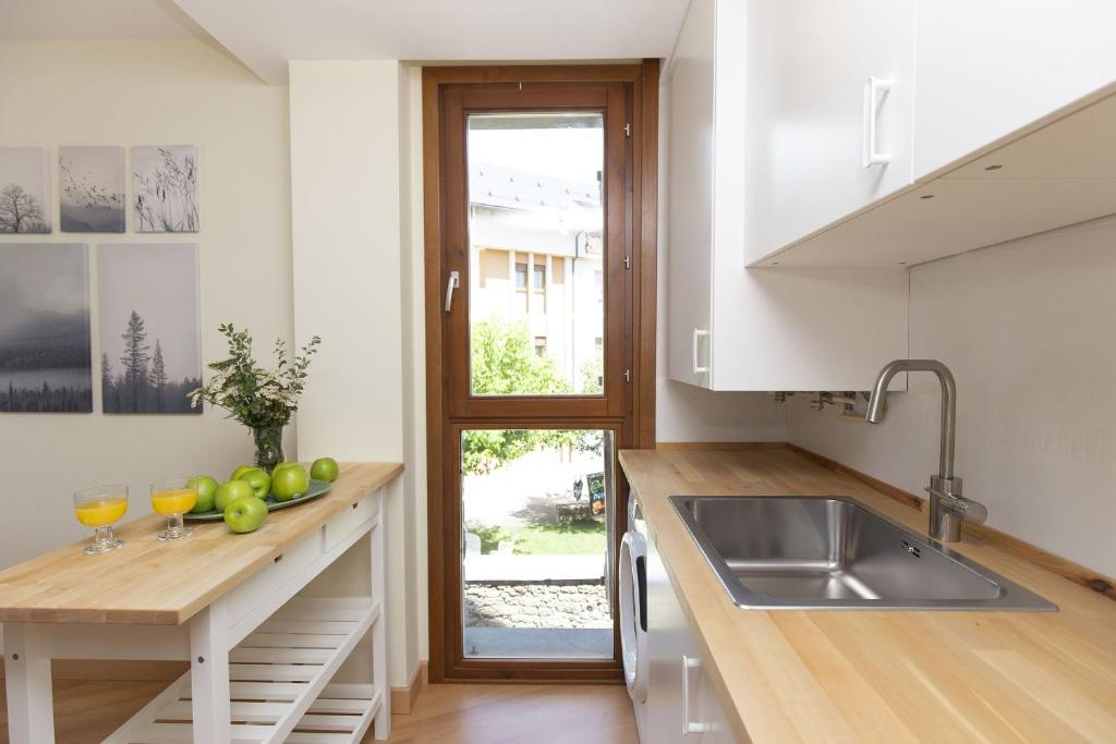 a kitchen with a sink and a counter with wine glasses at TenaNatura Ski by BeValle in Escarrilla