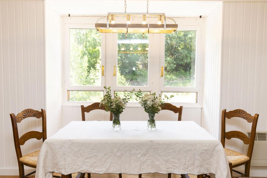 a dining room with a table with vases of flowers on it at Montibel by BeValle in Panticosa
