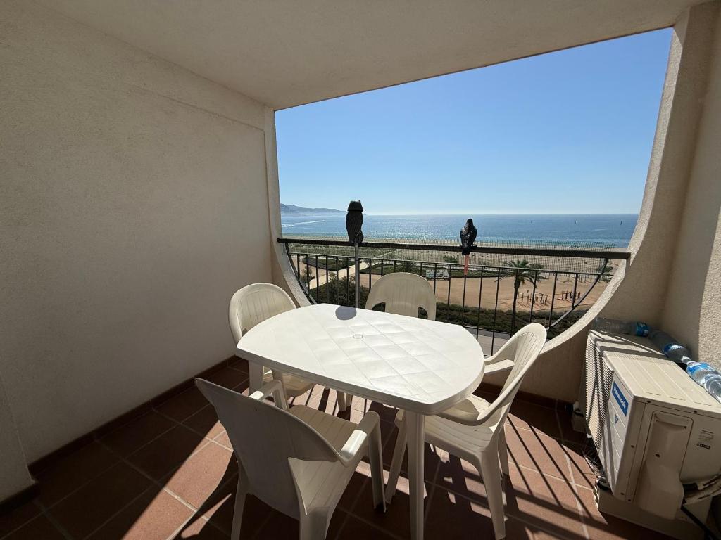 a balcony with a table and chairs and a view of the ocean at AwayDays - Apartamento en la 7a planta vista mar! in Empuriabrava