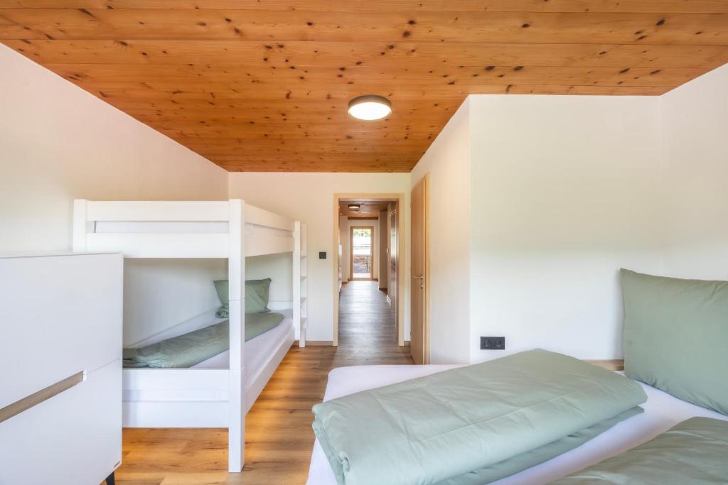 a bedroom with two bunk beds and a wooden ceiling at Egg'spresso Gipfelglück in Egg