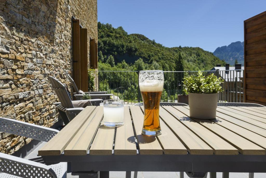 a wooden table with two glasses of beer on it at El Rincón del Verde by BeValle in Panticosa