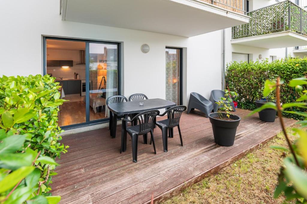 a patio with a table and chairs on a deck at Laïta - Séjour à Quimperlé in Quimperlé