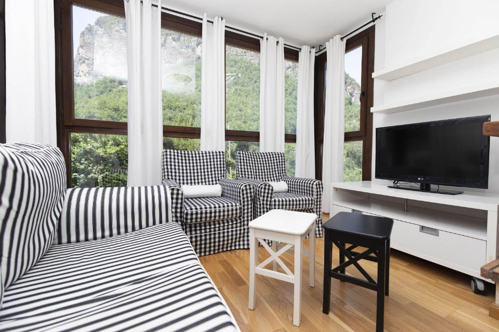 a living room with two chairs and a flat screen tv at Casa Eguzkilore by BeValle in Escarrilla