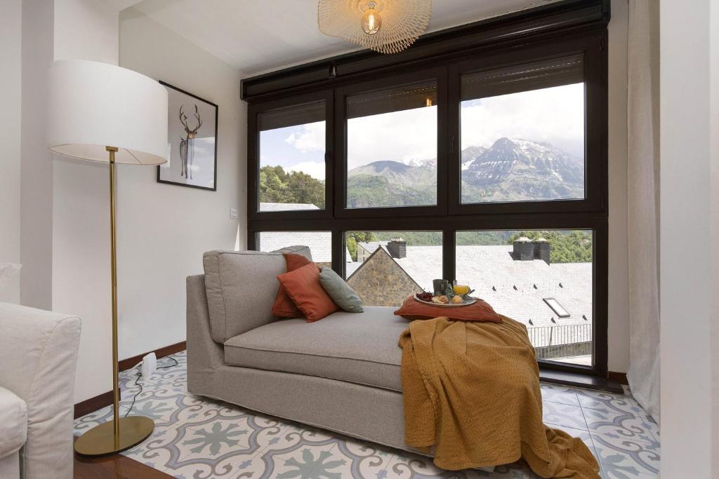 a living room with a couch and a large window at Partacua by BeValle in Tramacastilla de Tena