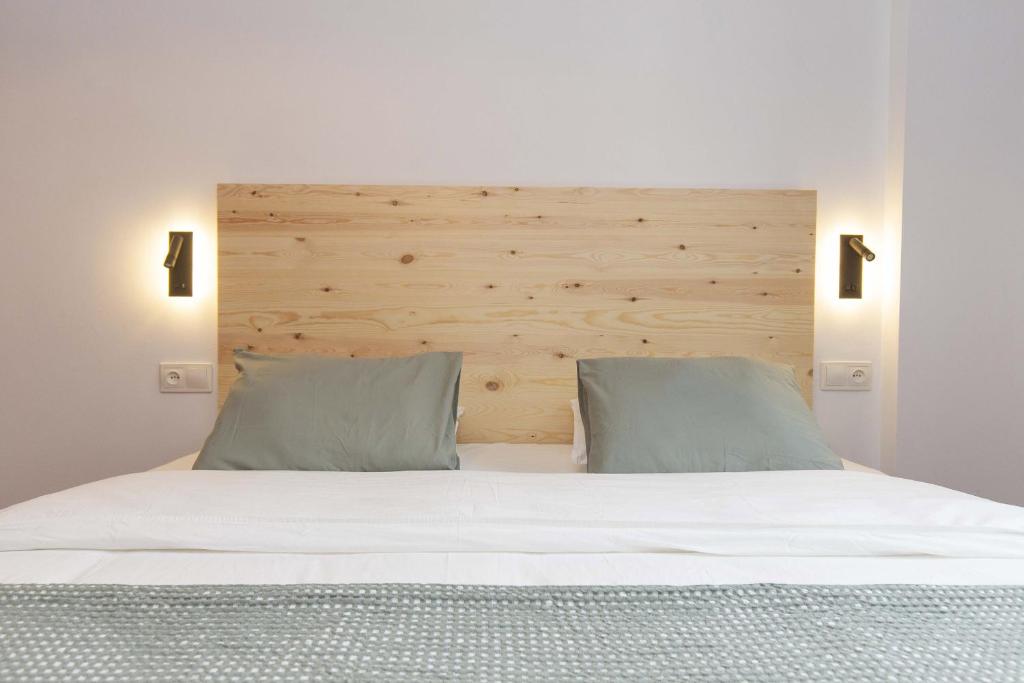 a bedroom with a large bed with a wooden headboard at Sueños de Telera by BeValle in El Pueyo de Jaca