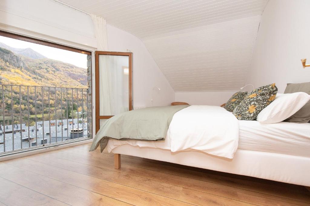 a bedroom with a bed and a large window at Panorámica del Valle II by BeValle in Panticosa
