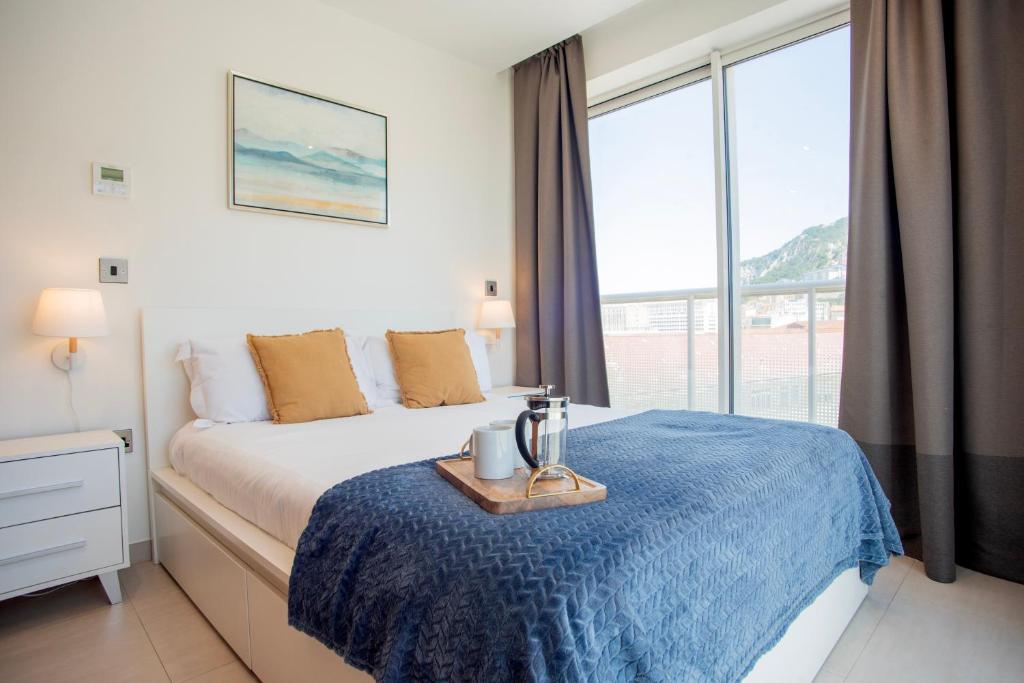 a bedroom with a bed and a large window at West One - Luggage Facility Available in Gibraltar
