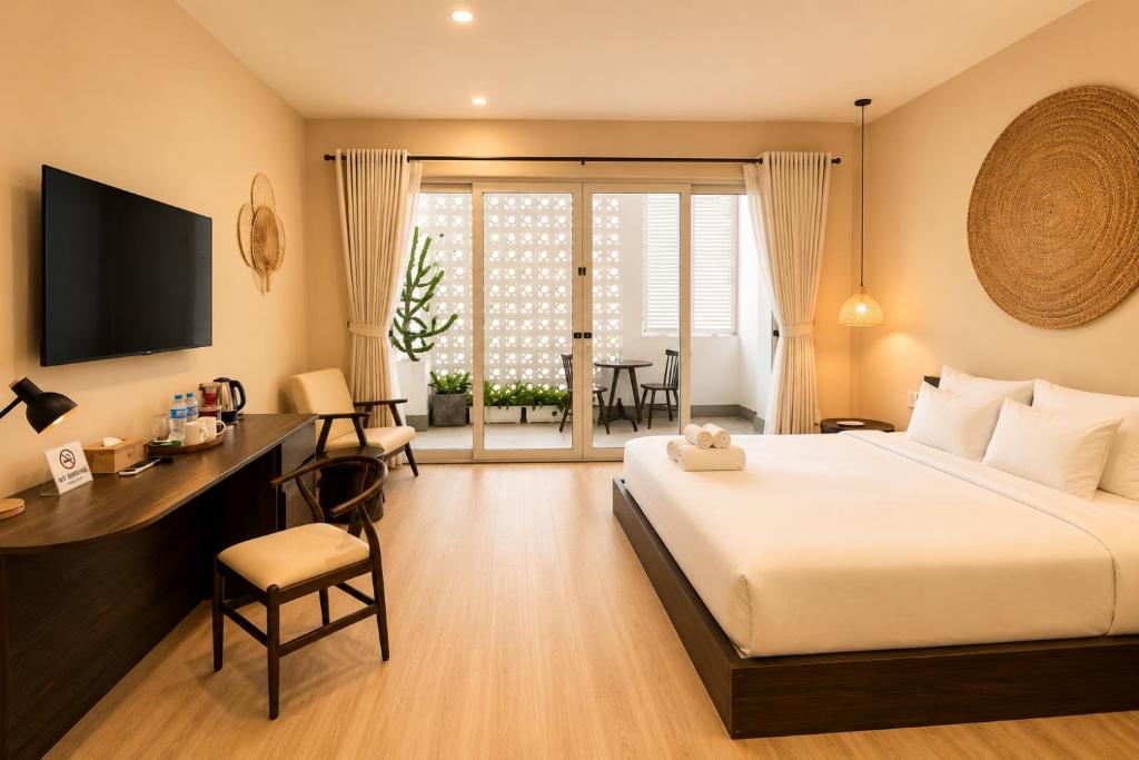 a hotel room with a bed and a desk and a table at HemTouch House - Nguyễn Văn Mai in Ho Chi Minh City