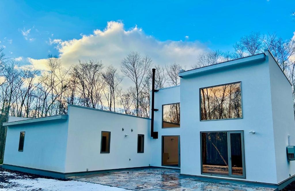 a large white house with windows on top of it at White Chalet Niseko in Niseko