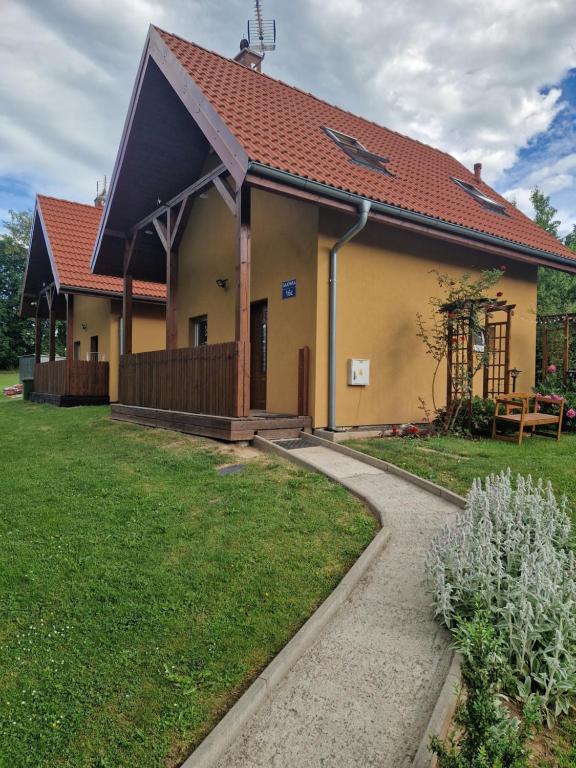 a large yellow house with a red roof at Gajówka in Radków