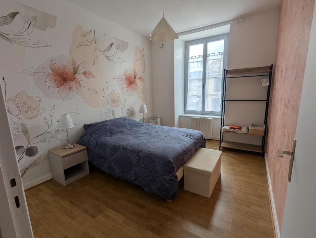 a bedroom with a bed and flowers on the wall at Appartement du parc in Ambert