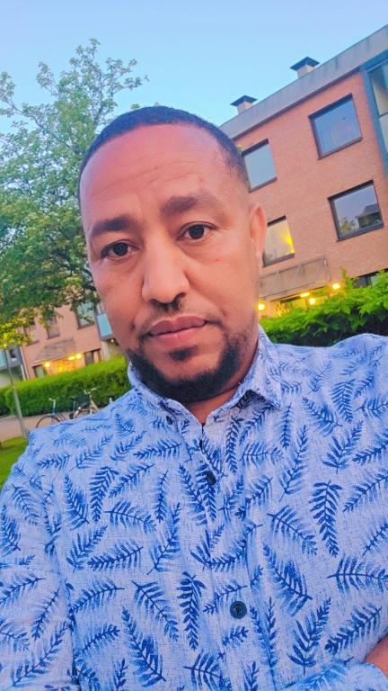 a man wearing a blue shirt and tie at Isayas Asfehale Welday in Halmstad