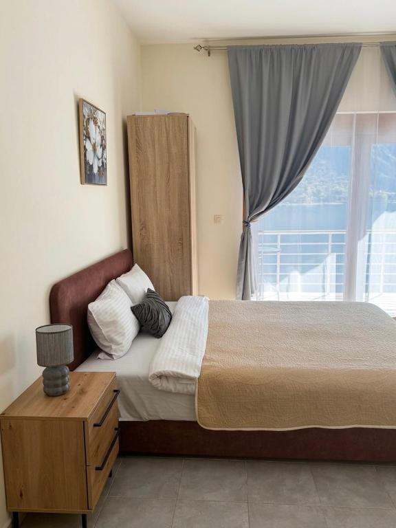 a bedroom with a large bed and a window at Apartments Sofia in Kotor