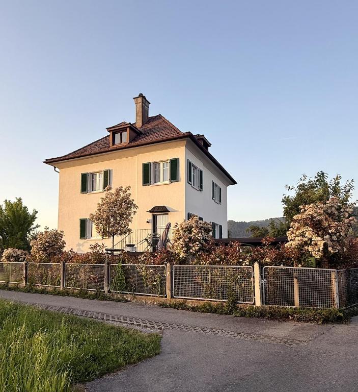 a house with a fence in front of it at Villa El Jardin Bodensee in Lochau