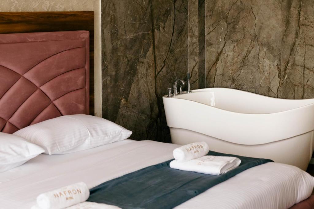 a bedroom with a bed and a bath tub at Nafron Hotel in Prizren