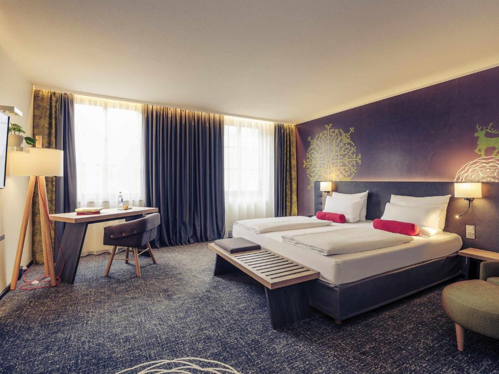 a hotel room with two beds and a desk at Mercure München City Center in Munich