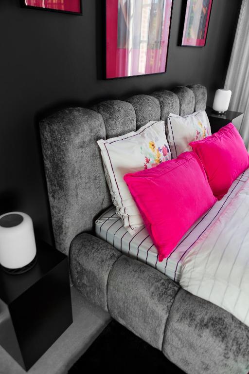 a couch with pink and white pillows on it at LE CHERCHE MIDI Chambres d'hôtes avec CUISINE EQUIPEE grand jardin PARKING SECURISE GRATUIT in Albi
