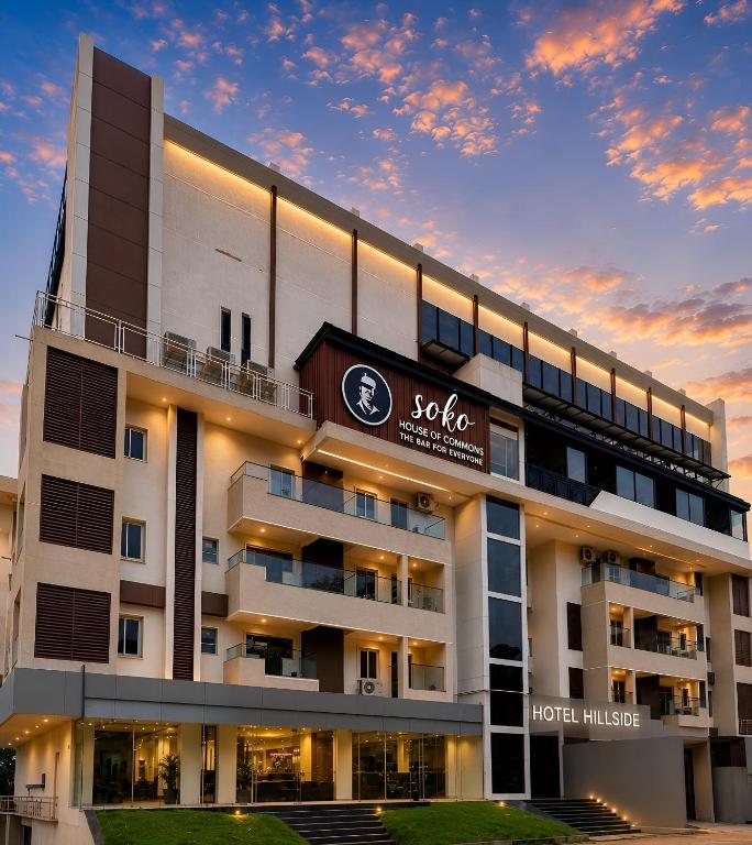 a hotel with a sign on the front of it at Hillside Hotel in Mysore