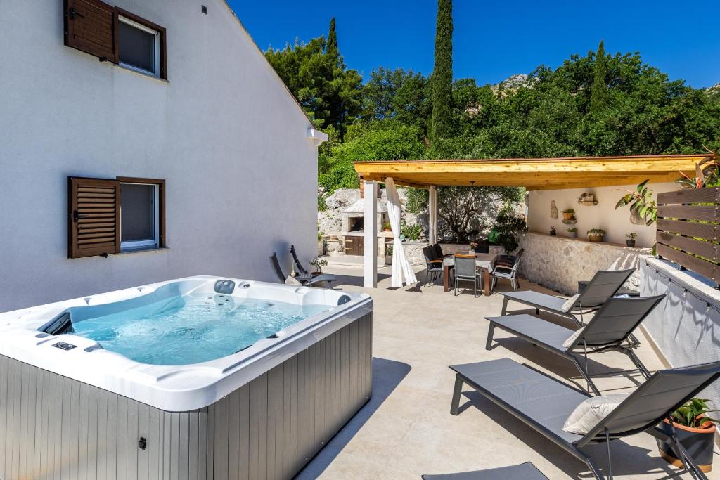 a hot tub on the patio of a house at NIMA Cozy Stay Mlini in Mlini