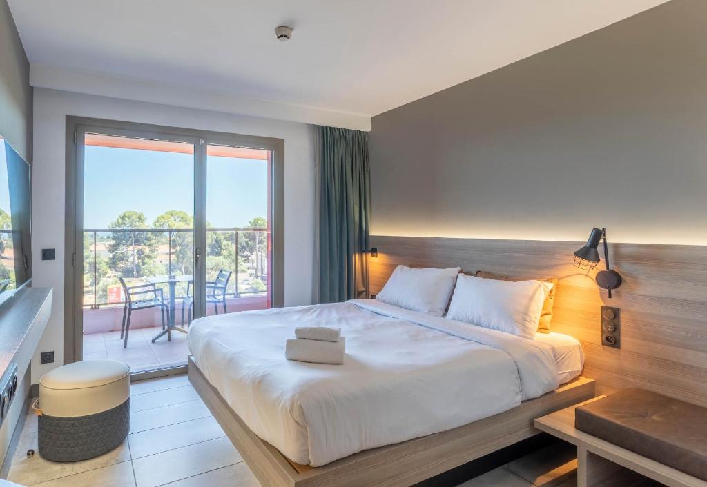 a bedroom with a large bed and a balcony at B&B HOME La Ciotat in La Ciotat