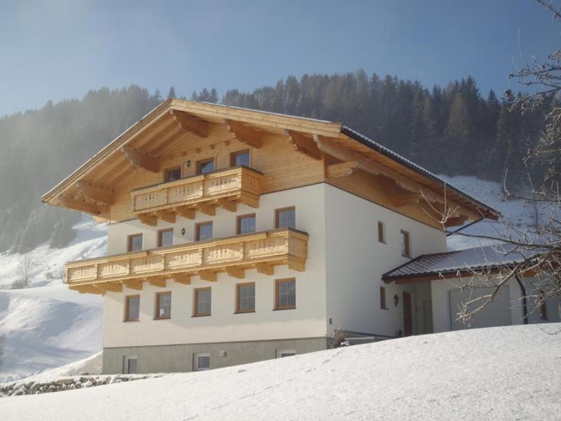 a building with a wooden balcony on top of snow at Stapfgut in Rauris