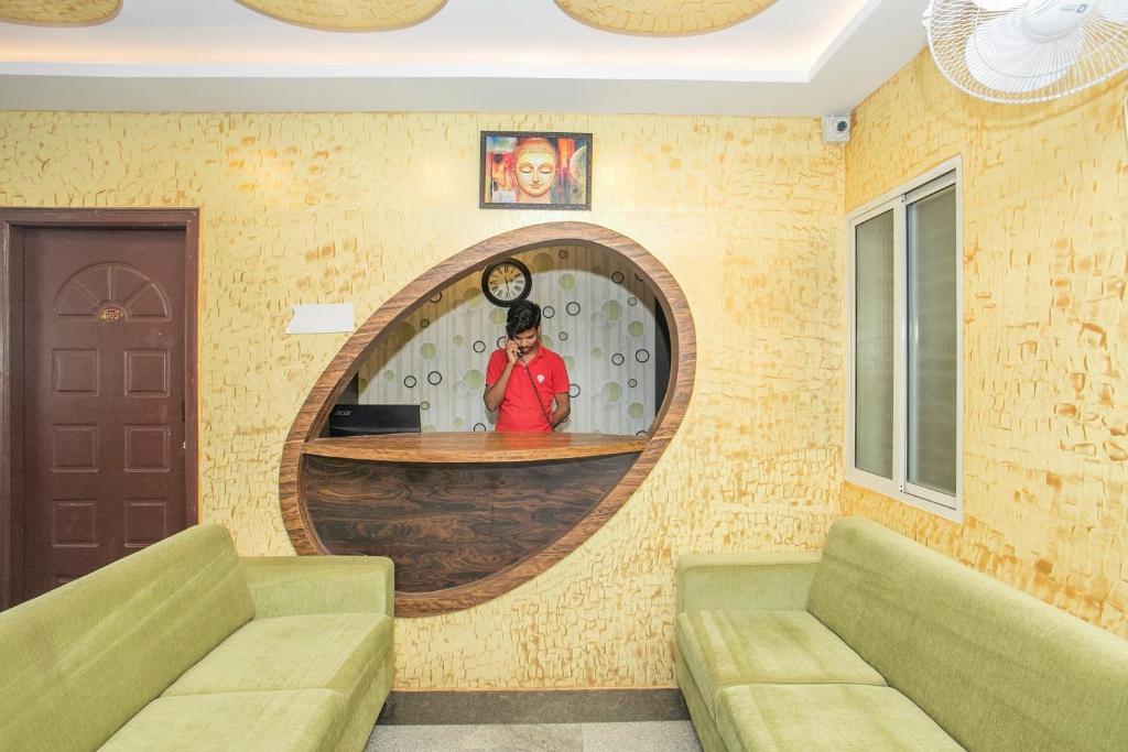 a room with a wall with a round mirror at Collection O Royal Mac in Bangalore