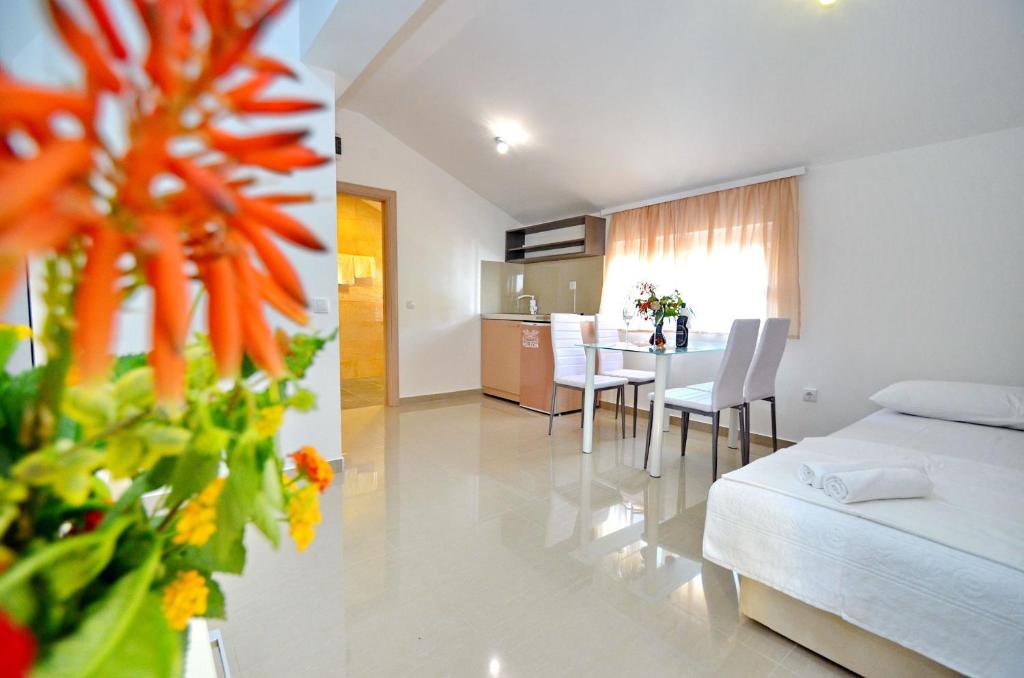 a room with a bed and a table and chairs at Villa Velzon Lux in Budva