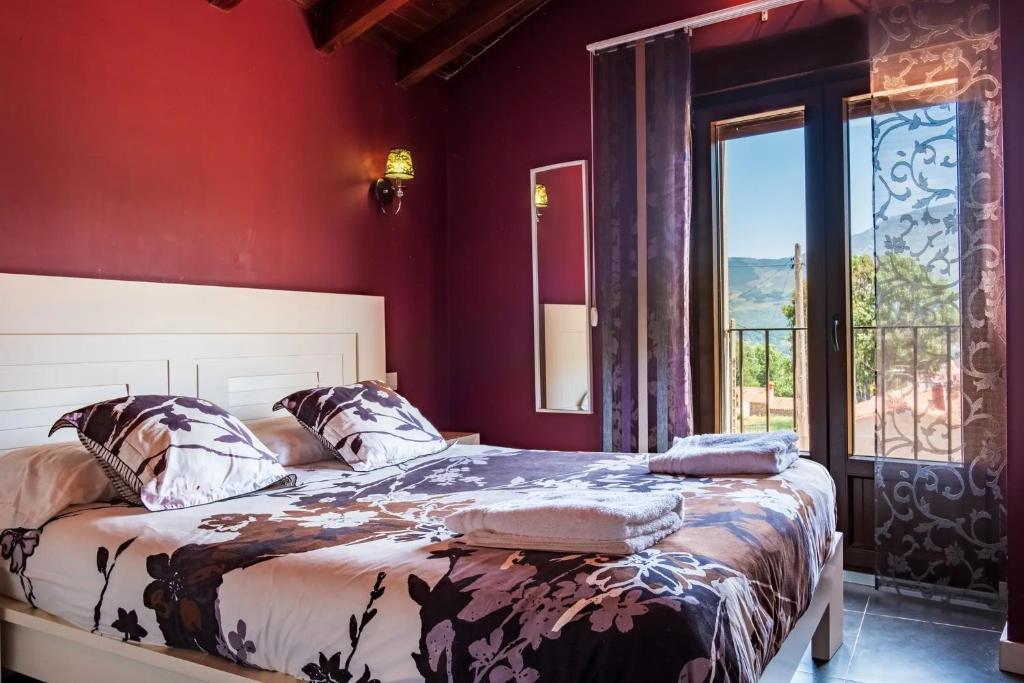 a bedroom with a bed and a large window at Baelo Claudia in Navalguijo