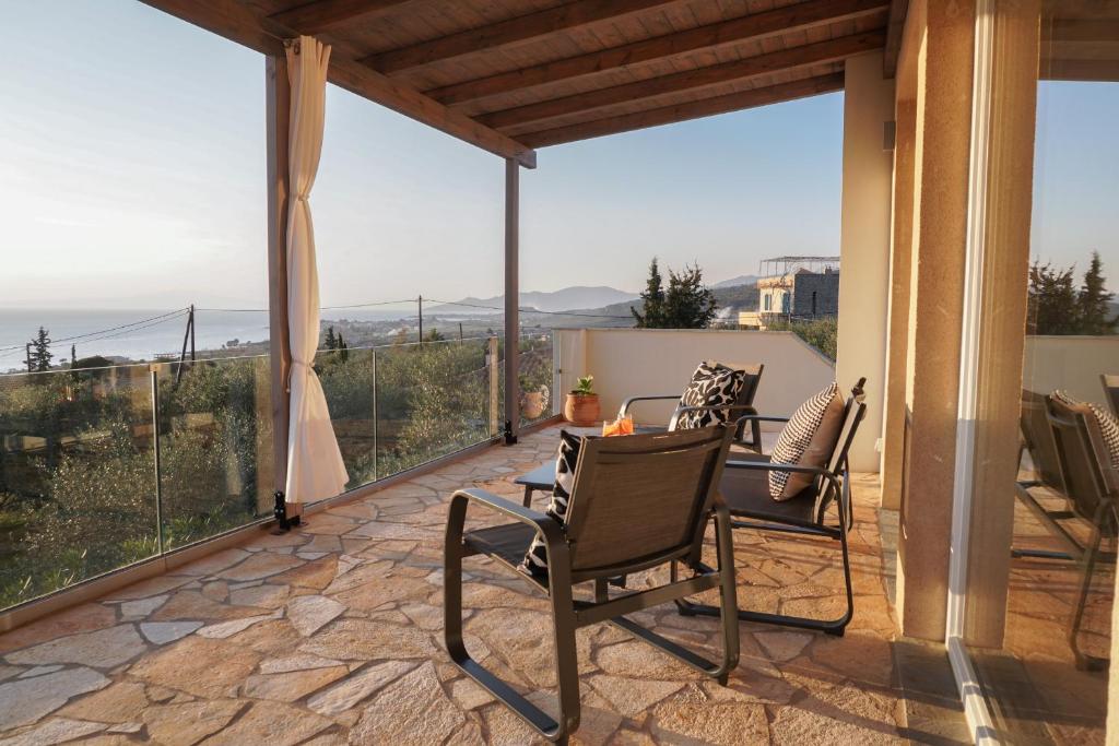 a patio with chairs and a table with a view at Philia-Modern Living with Panoramic Sea View in Kotrónion