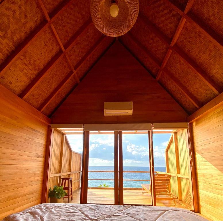a bedroom with a bed and a view of the ocean at Aresona Cliff House in Bira