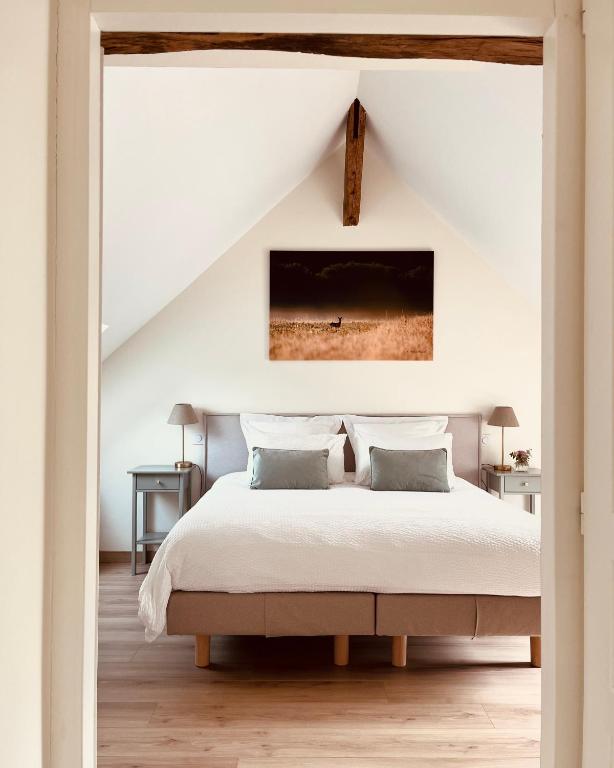 a bedroom with a large bed with white sheets at MAISON MOZ entre Chambord & Cheverny in Fontaines-en-Sologne