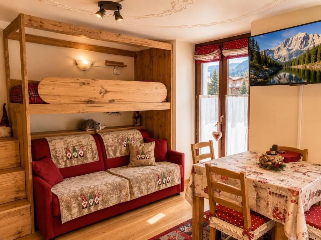 a bedroom with a bunk bed and a table at Le Petit Refuge in La Thuile