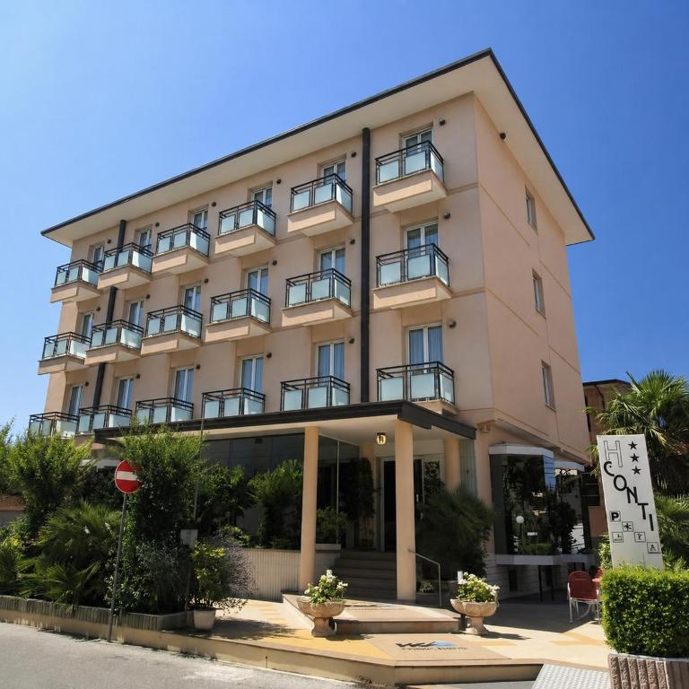 a building with a sign in front of it at Hotel Conti in Rimini