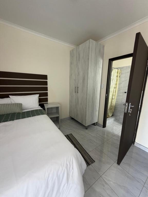 a bedroom with a large bed and a closet at Coastwave Guesthouse CBD in Walvis Bay