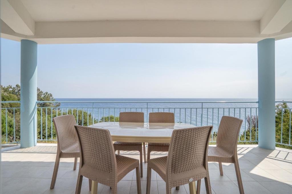 a dining room with a table and chairs on a balcony at Perseus in Cape Sarakiniko in Argostoli
