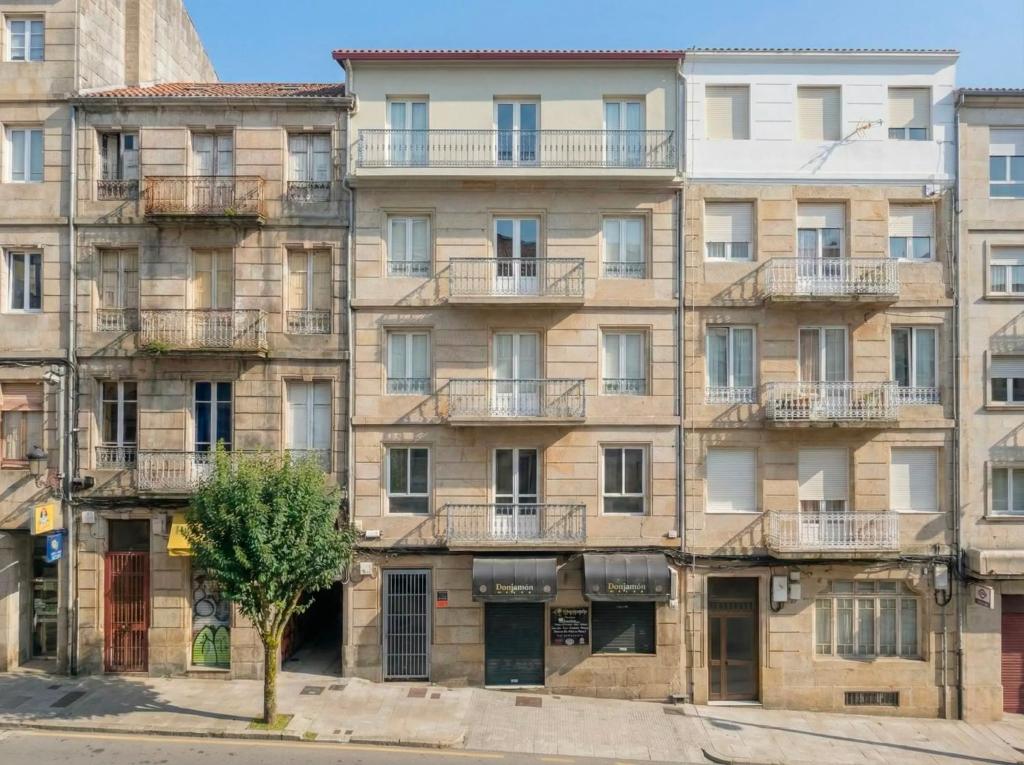 an apartment building with a tree in front of it at YBH Ocean Boutique in Vigo