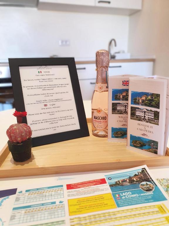 a table with a menu and a bottle of wine at Petra's House in Lenno