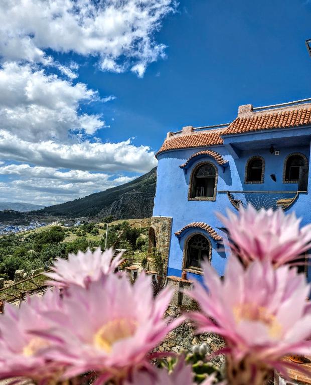 a blue building with pink flowers in front of it at Haven Hills Chaouen in Chefchaouen